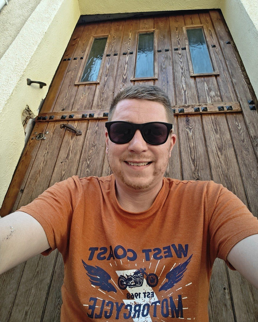 Sam in front of an old wooden door in Catalonia